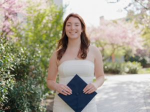a white woman with red/brown hair wearing a Villanova t-shirt, smiles at the camera.